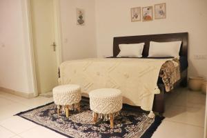 a bedroom with a large bed with two stools at Gypsy Soul Gateaway - Casa Boho in Zirakpur