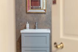 a bathroom with a white sink and a mirror at Quiet, charming countryside retreat nr. the capital of the Cotswolds in Cirencester