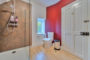 a bathroom with a toilet and a glass shower at Quiet, charming countryside retreat nr. the capital of the Cotswolds in Cirencester