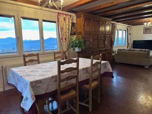 a dining room with a table and chairs and windows at Le chalet st hubert in Montcel +9 photos