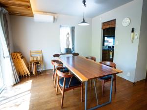 a dining room with a wooden table and chairs at バケーションイン伊豆高原 in Ito
