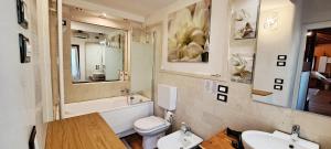a bathroom with two sinks and a toilet and a mirror at open space apt - comodo a Venezia in Treviso +18 photos
