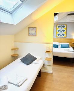 two beds in a room with a attic at La Carpe d'Or in Fontainebleau