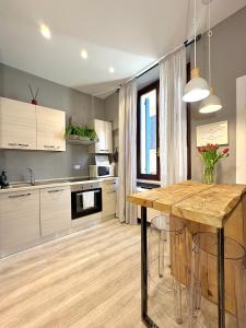 a kitchen with a wooden table with stools at Cantore 20 - Le Arche Verona in Verona