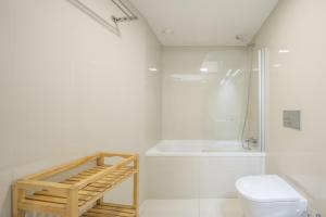 a white bathroom with a toilet and a shower at Aspasios Trindade Apartments in Porto