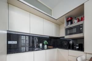 a kitchen with white cabinets and a black counter top at Aspasios Trindade Apartments in Porto +10 photos