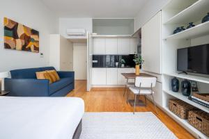 a living room with a blue couch and a kitchen at Aspasios Trindade Apartments in Porto