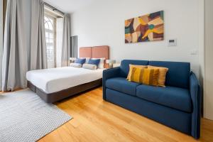 a bedroom with a bed and a blue couch at Aspasios Trindade Apartments in Porto