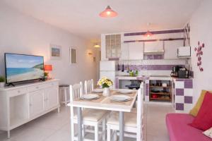 a kitchen and dining room with a table and chairs at Sunny Pool Apartment Costa del Silencio in Arona