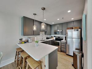 a kitchen with a refrigerator and a counter top at Commodores Retreat #205 in Santa Rosa Beach +12 photos