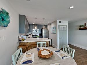 a kitchen and dining room with a table and chairs at Commodores Retreat #205 in Santa Rosa Beach
