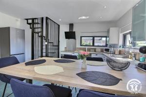 a dining room table with chairs and a kitchen at ô nid des grèves in Langueux