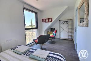 a bedroom with a bed and a desk and a window at ô nid des grèves in Langueux