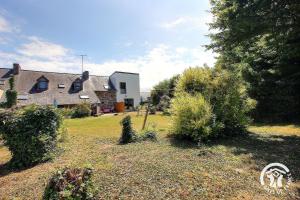 a house and a yard with trees and bushes at ô nid des grèves in Langueux