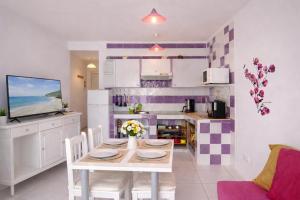 a kitchen and dining room with a table and chairs at Sunny Pool Apartment Costa del Silencio in Arona +9 photos