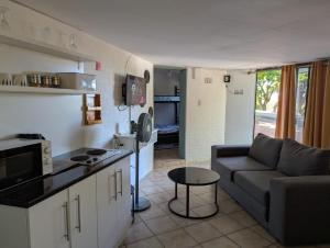 a kitchen and living room with a couch and a table at Carravensiria Chalet 27 in Hibberdene