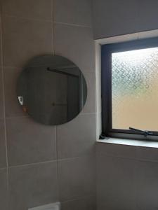 a bathroom with a mirror and a window at Carravensiria Chalet 27 in Hibberdene +9 photos