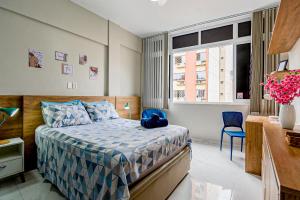 a bedroom with a bed and a desk and a window at Charme da Santa Clara in Rio de Janeiro