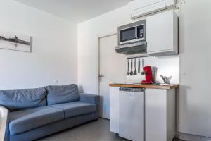 a living room with a couch and a microwave at Blue Bird - Logement sur les Ramblas in Toulouse
