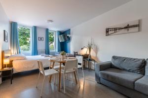 a room with a bed and a table and a couch at Blue Bird - Logement sur les Ramblas in Toulouse