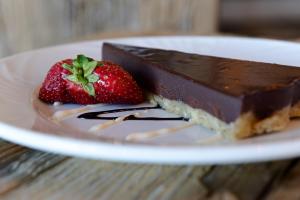 a piece of chocolate cake and strawberries on a plate at Riotel Perce in Perce