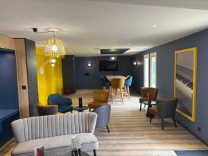 a living room with a couch and chairs and a table at Hotel ibis Autun in Autun