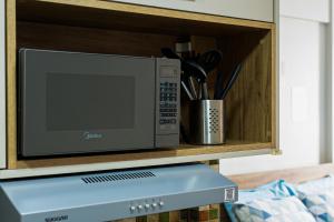 a microwave oven sitting on a wooden shelf at Charme da Santa Clara in Rio de Janeiro