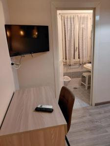 a room with a table and a television on a wall at Piazza del Popolo Suites in Rome