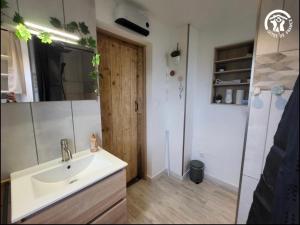 a bathroom with a sink and a wooden door at Au rucher in Fressin +21 photos
