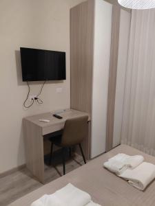 a room with a desk with a television and a chair at Piazza del Popolo Suites in Rome +9 photos