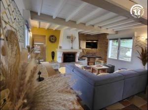 a living room with a blue couch and a fireplace at Au rucher in Fressin