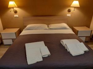 a large bed with two white towels on it at Piazza del Popolo Suites in Rome
