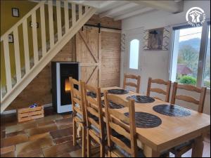 a dining room with a table and chairs and a staircase at Au rucher in Fressin