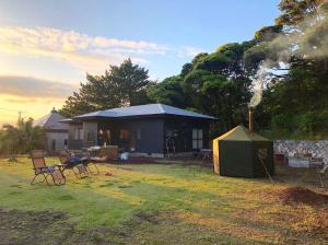 a tent and chairs in front of a house at Big Island Base 一組限定の庭付き一棟貸し BBQ 焚き火 テントサウナ 最大6名 in Oshima