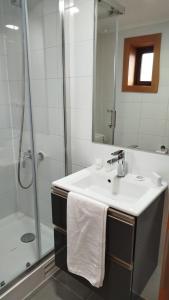 a white bathroom with a sink and a shower at Hotel Los Ríos in Panguipulli