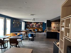 a dining room with tables and chairs and blue walls at Hotel ibis Autun in Autun