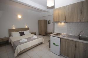 a bedroom with a bed and a kitchen with a sink at PortoDream Studios & Apartments in Neos Marmaras