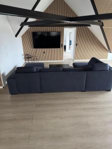 a living room with a couch and a flat screen tv at Stor villa til 16 gæster Sauna & vildmarksbad 200 m strand in Børkop