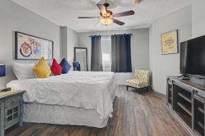 a bedroom with a bed and a ceiling fan at Shop & Dine: Fort Worth Condo w/ Racetrack Views! in Fort Worth +37 photos