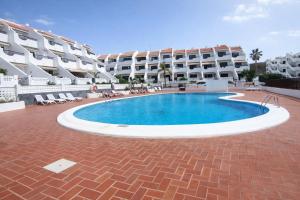 a large swimming pool in front of a building at Sunny Pool Apartment Costa del Silencio in Arona