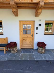 two baskets of flowers in front of a door at Ferienwohnung Altrach in Aurach bei Kitzbuhel