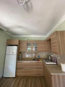 a kitchen with wooden cabinets and a white refrigerator at Konak village housee in Ardeşen