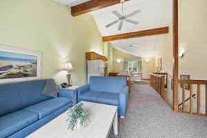 ein Wohnzimmer mit einem blauen Sofa und einem Tisch in der Unterkunft Ocean Pines Resort in Duck