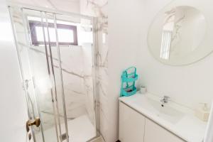 a white bathroom with a shower and a sink at Guest H4U Povoa Vacation City center in Póvoa de Varzim +34 photos
