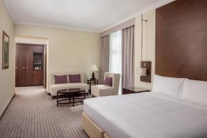 a hotel room with a large bed and a chair at Radisson Blu Hotel, Dubai Barsha Heights in Dubai