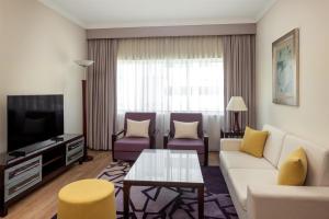 a living room with a couch and a tv at Radisson Blu Hotel, Dubai Barsha Heights in Dubai +98 photos
