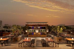 a rooftop patio with tables and a building at Radisson Blu Hotel, Dubai Barsha Heights in Dubai