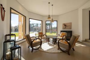a living room with chairs and a table and a fireplace at Villa Yliane in Marrakesh
