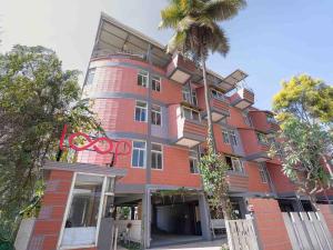 a red brick building with a palm tree in front of it at Z Stays, Silkboard in Bangalore