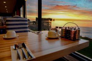 a table with plates and utensils on a table with a view at Riotel Perce in Perce